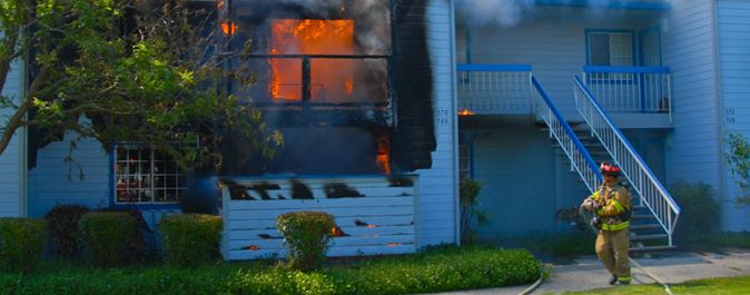 firefighter outside burning house